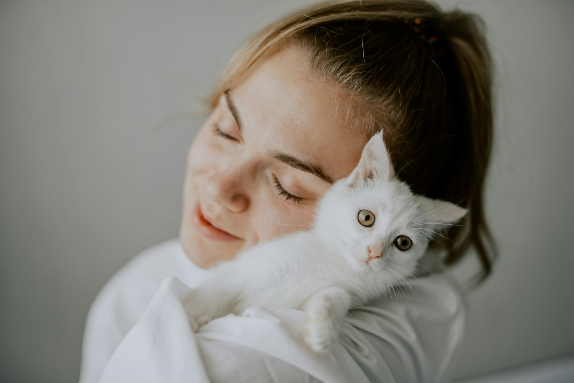 Pemilik haiwan memeluk anak kucing putih